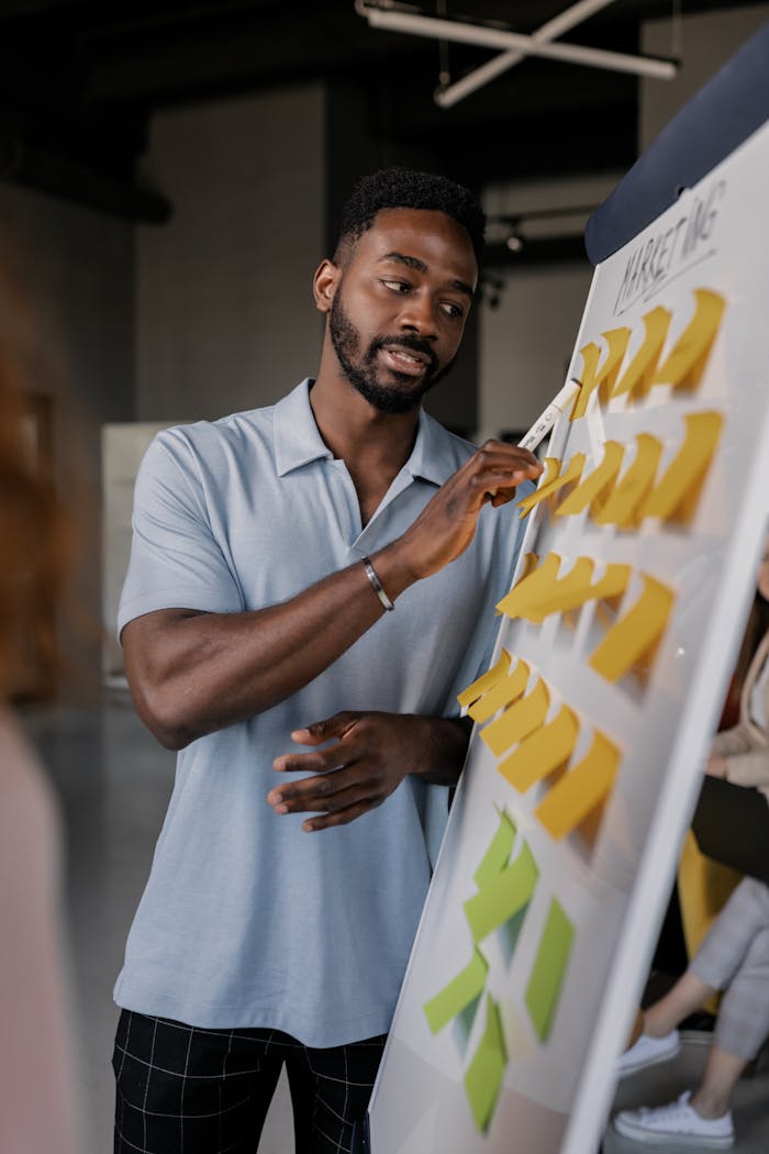 services-cta Confident African American man presenting business strategy using sticky notes on whiteboard.