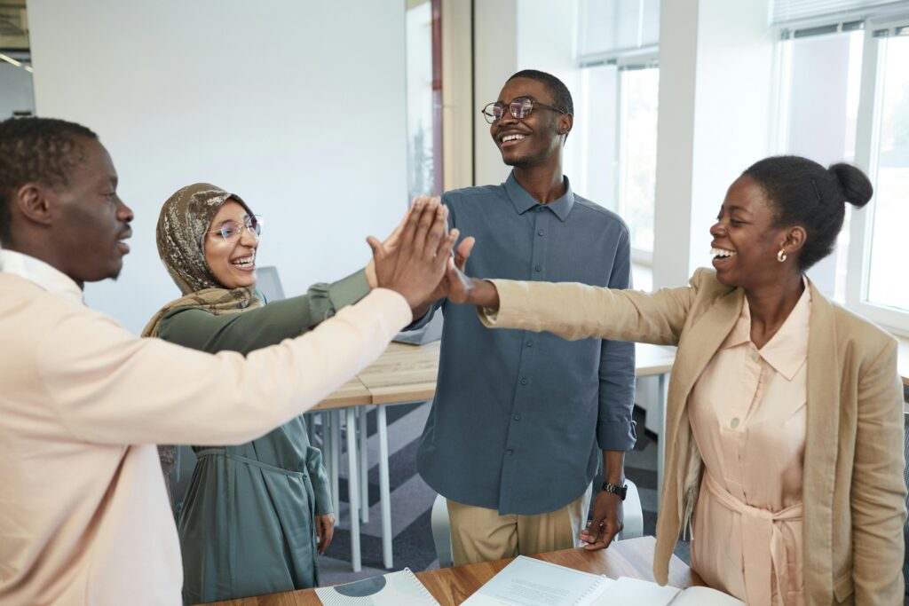 pexels photo 8553867 8553867 A joyful group of diverse colleagues high-fiving each other in an office, symbolizing teamwork and collaboration.